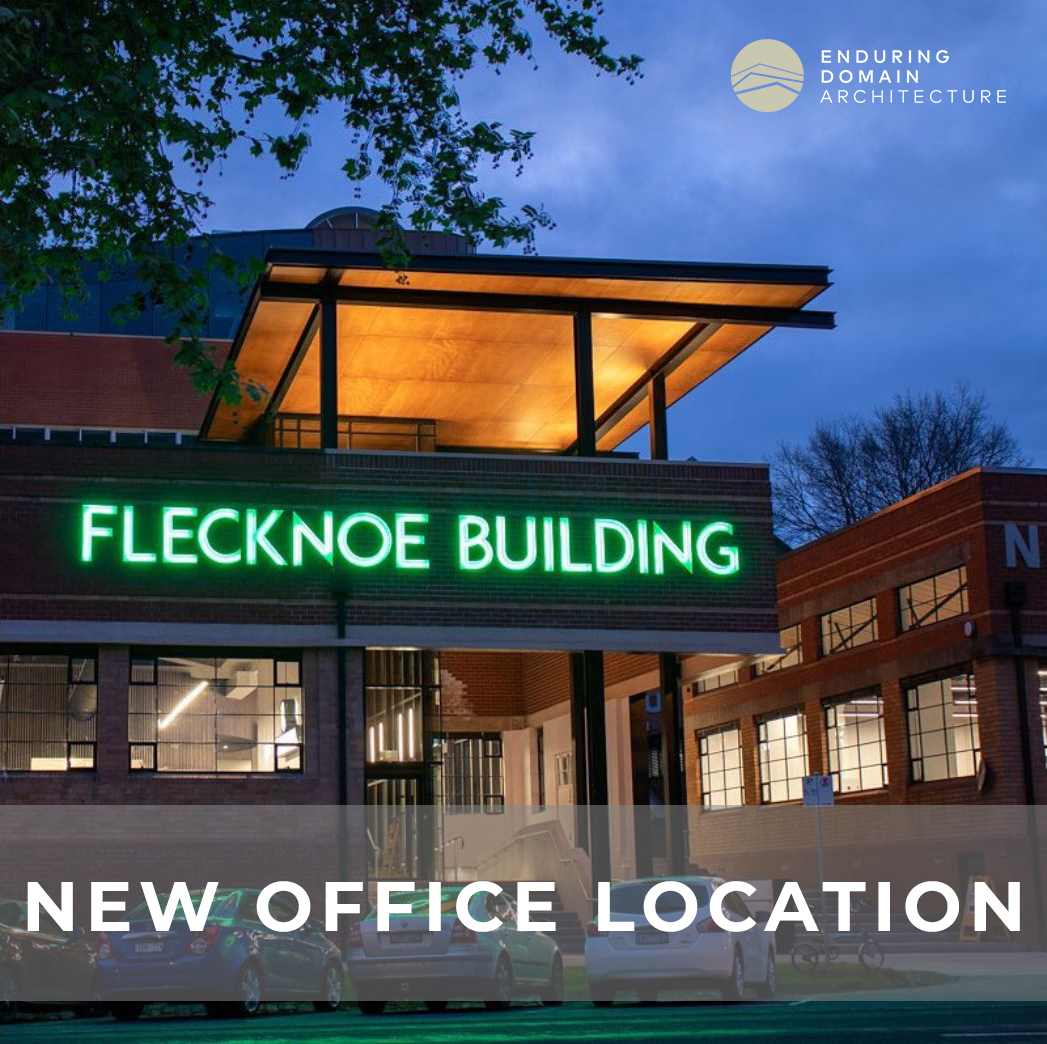 The Flecknoe building illuminated at night with a large neon sign. Text overlay reading "new office location"